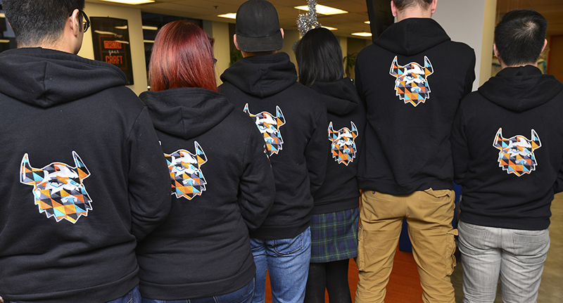 Entripy clients posing with their black custom hoodies, which were embroidered with high stitch count.