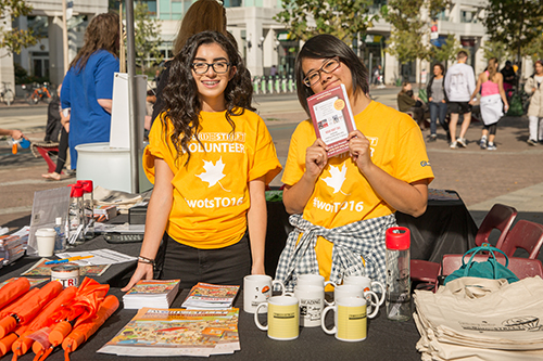 Volunteers at The Word on the Street festival showcasing custom t-shirts, books, custom bags and custom mugs.