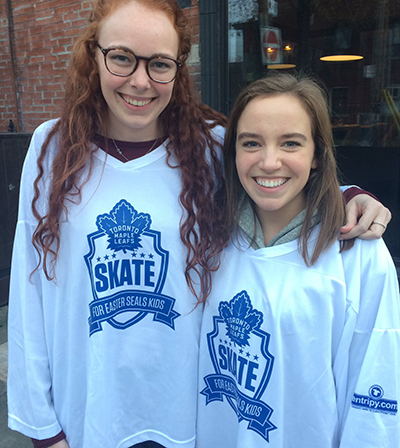 Volunteers at Easter Seals Skate wearing white custom jerseys of Toronto Maple Leafs.