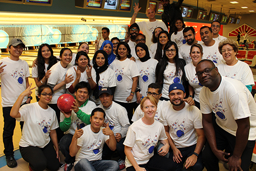 Entripy employees at a bowling event wearing custom t-shirts with Entripy logo and personalized with names.