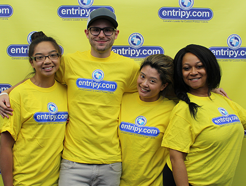Entripy employees wearing yellow custom printed t-shirts.