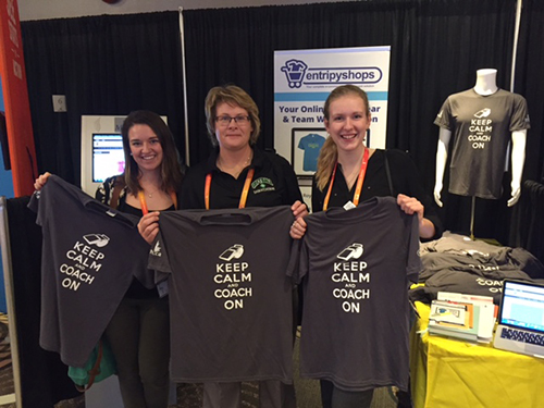 Customers holding black custom t-shirts at a trade show for EntripyShops.