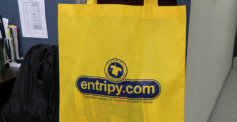 Entripy's yellow custom tote bag used as a conference swag bag at tradeshows.