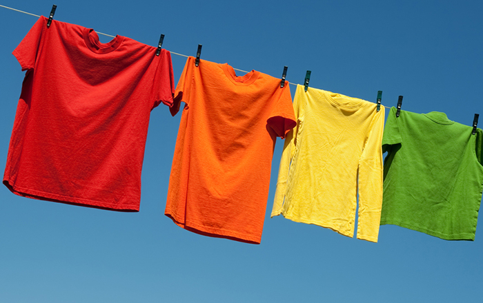 Colourful custom t-shirts hanging outside to dry for preserving the colour and custom logo.