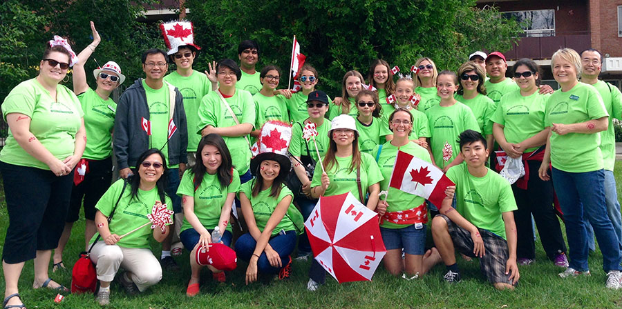 Group of participants displaying their green custom shirts at a charity event for the Mississauga Food Bank.