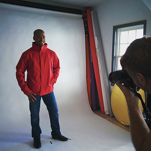 Model posing wearing red zip up custom jacket for a photoshoot.