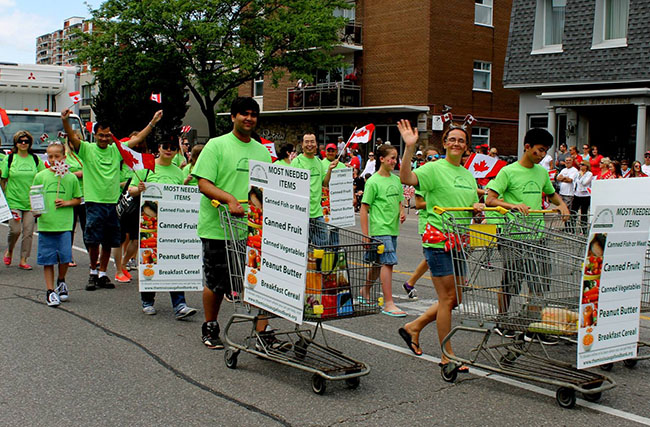 Participants wearing custom clothing and raising community food drives with shopping carts filled with food for the Mississauga Food Bank.
