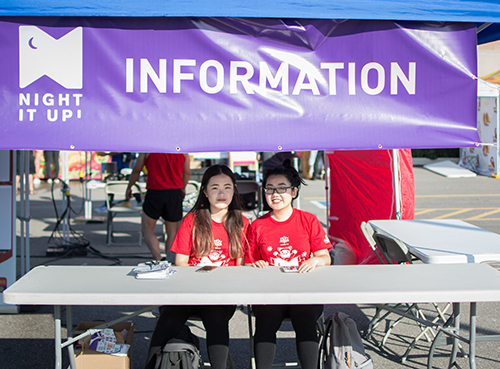 Event information booth with volunteers wearing custom printed t-shirts.