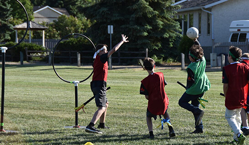 Students playing Quidditch wearing red and green custom jerseys.