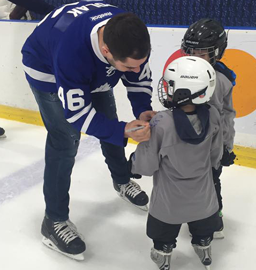 Roman Polak from Maple Leafs signing kids custom jerseys at Easter Seals skate.