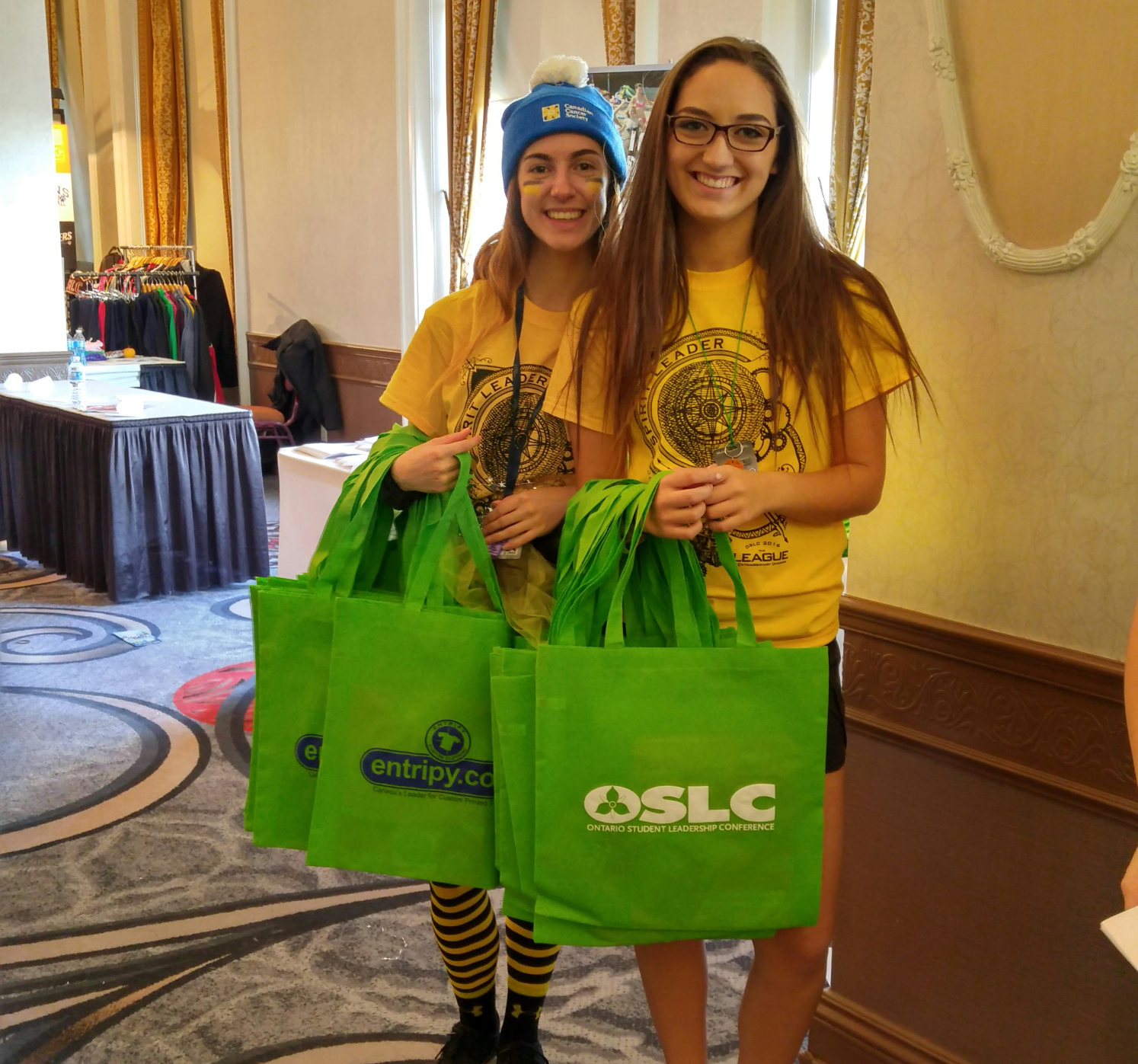 Students wearing custom t-shirts, embroidered toques and displaying custom printed totes.
