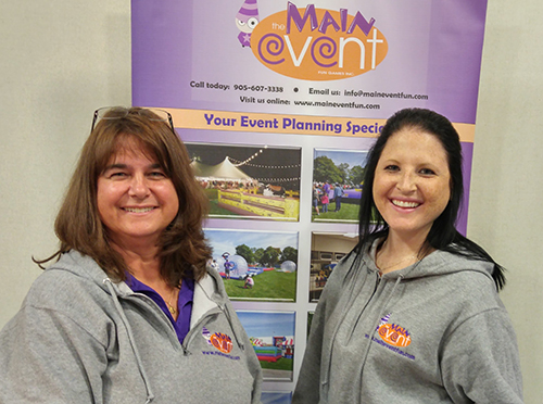 Clients at a trade show wearing their grey custom sweatshirts with their company logo.