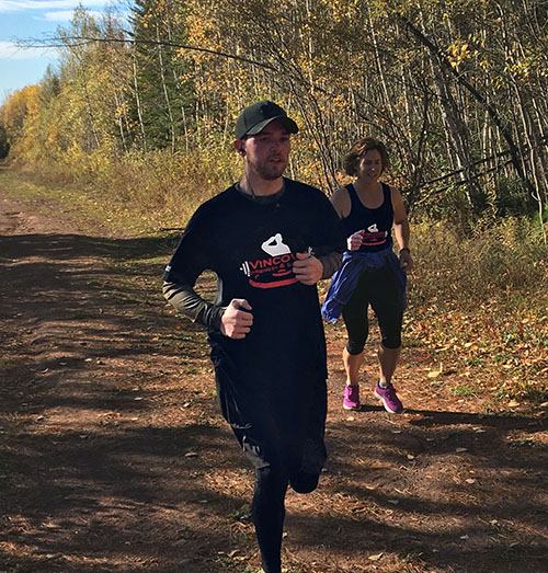 Participant running wearing a black custom t-shirt for a veterans non-profit organization.