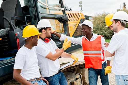 Construction employees discussing work wearing custom t-shirts and high-visibility vests.