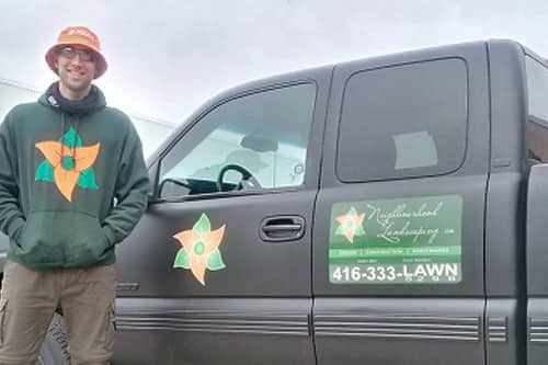 Landscaping services company working wearing custom t-shirt and embroidered hat with logo.