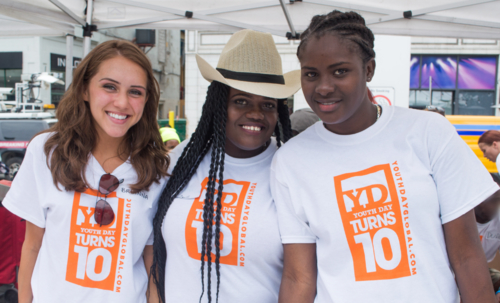 Youth day volunteers wearing custom t-shirts in white with their safety orange design that stands out.