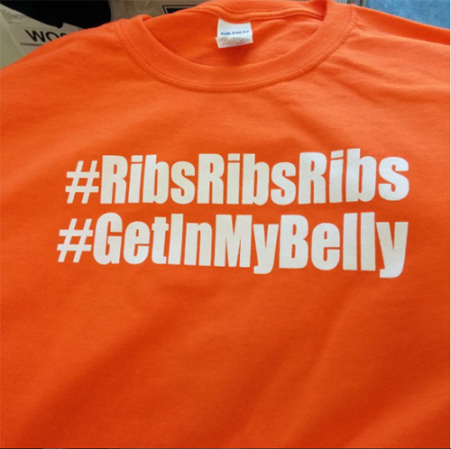 Hashtags printed on orange custom t-shirts for an outdoor food festival.