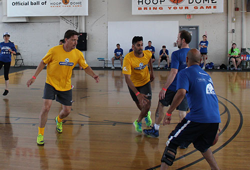 Two teams competing in basketball wearing custom t-shirts with personalized names and numbers.
