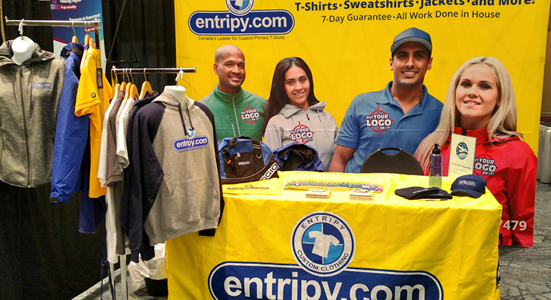 Entripy at a trade show event showcasing custom apparel including custom sweatshirts, custom t-shirts & promotional giveaways.