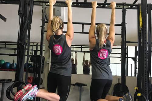 Individuals exercising in class wearing customized t-shirts.