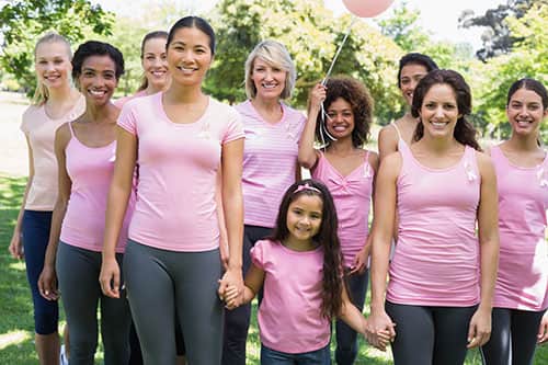 Group of females wearing pink custom t-shirts representing breast cancer.