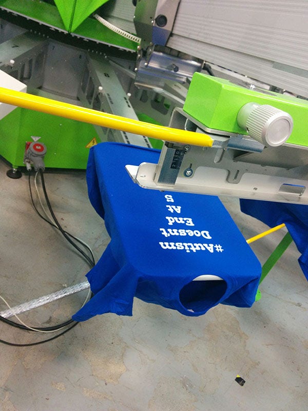 Custom t-shirt printing a custom design with ROQ screen-printing press.